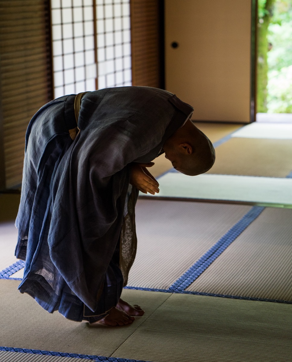 Monk in deep bow — Kyoto temple